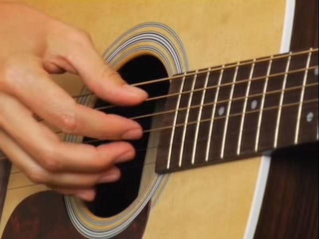 how to hold a guitar